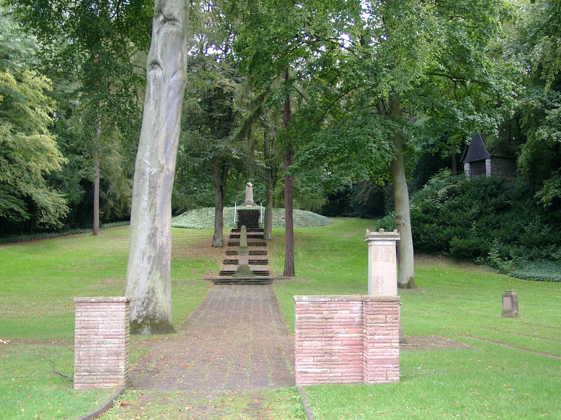 Geradliniger Zugang zum Alliierten-Ehrenfriedhof zwischen Backsteinpfeilern auf Hauptfriedhof Koblenz